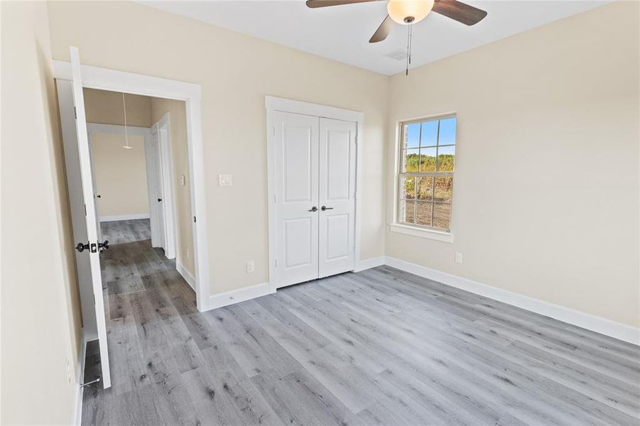 Unfurnished bedroom featuring a closet, ceiling fan, and light hardwood / wood-style floors