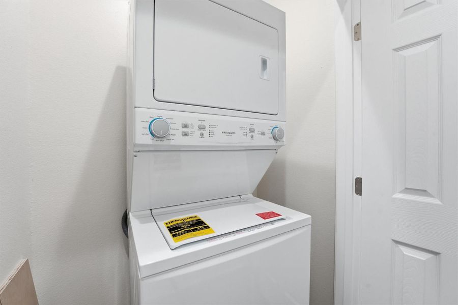 A convenient hall laundry area includes a full-size washer and dryer, adding everyday ease and turnkey appeal for both personal use and short-term rental operations.