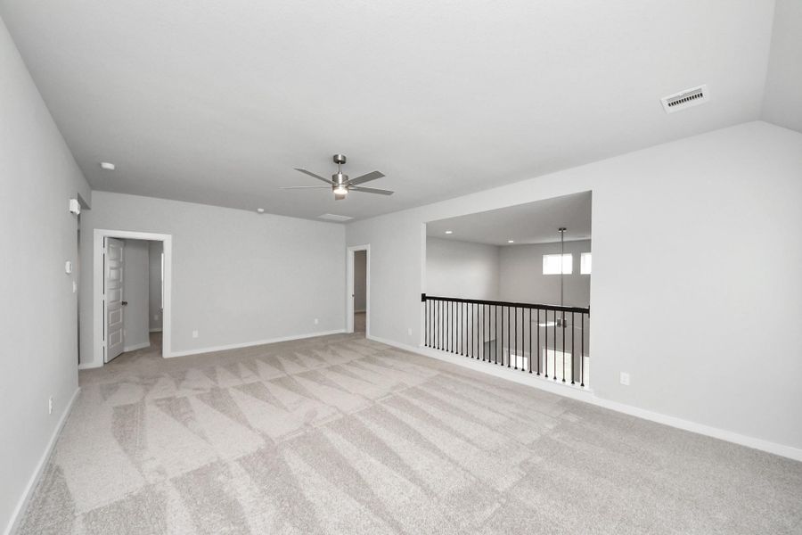 Ascend to relaxation in this fantastic game room! Ideal for both casual gatherings and adult gaming, it boasts plush carpet, lofty ceilings, custom paint, and ample windows for abundant natural light. Sample photo of completed home with similar floor plan. Actual colors and selections may vary.