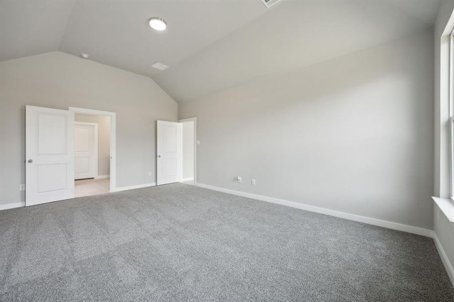 The primary bedroom features vaulted ceilings