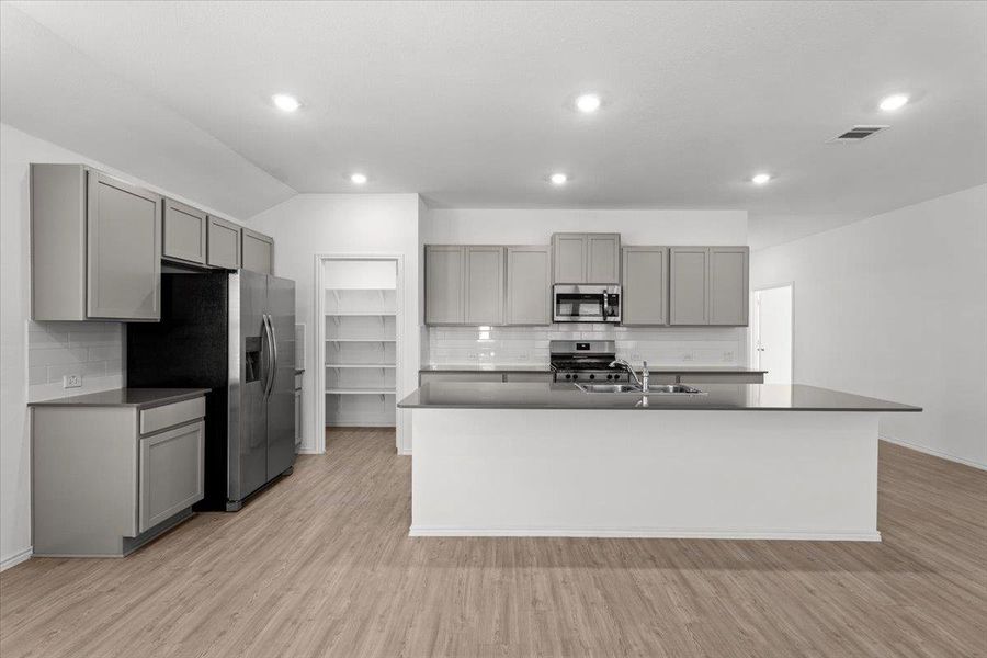 A contemporary kitchen featuring abundant cabinet storage and sleek, dark countertops. A contemporary kitchen featuring abundant cabinet storage and sleek, dark countertops.