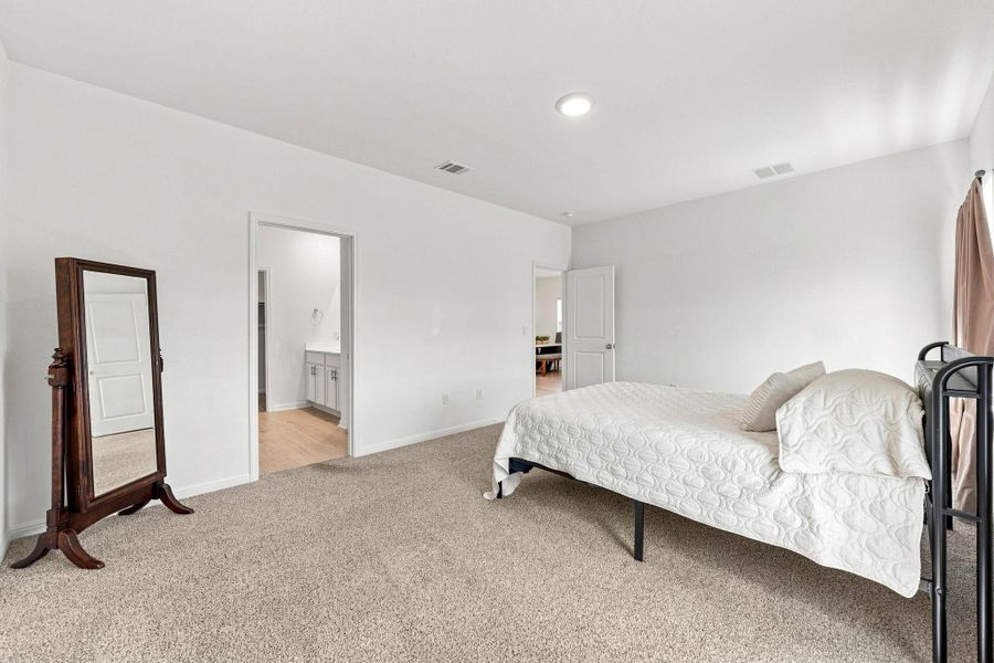 Plush carpeting underfoot anchors this quiet bedroom retreat featuring an attached master bathroom.