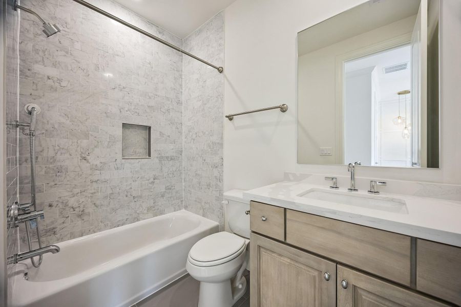 Secondary en-suite bath with tub/shower combination and timeless neutral finishes.