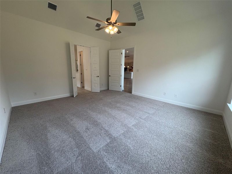 Unfurnished bedroom with carpet flooring, baseboards, and ceiling fan Unfurnished bedroom with carpet flooring, baseboards, and ceiling fan