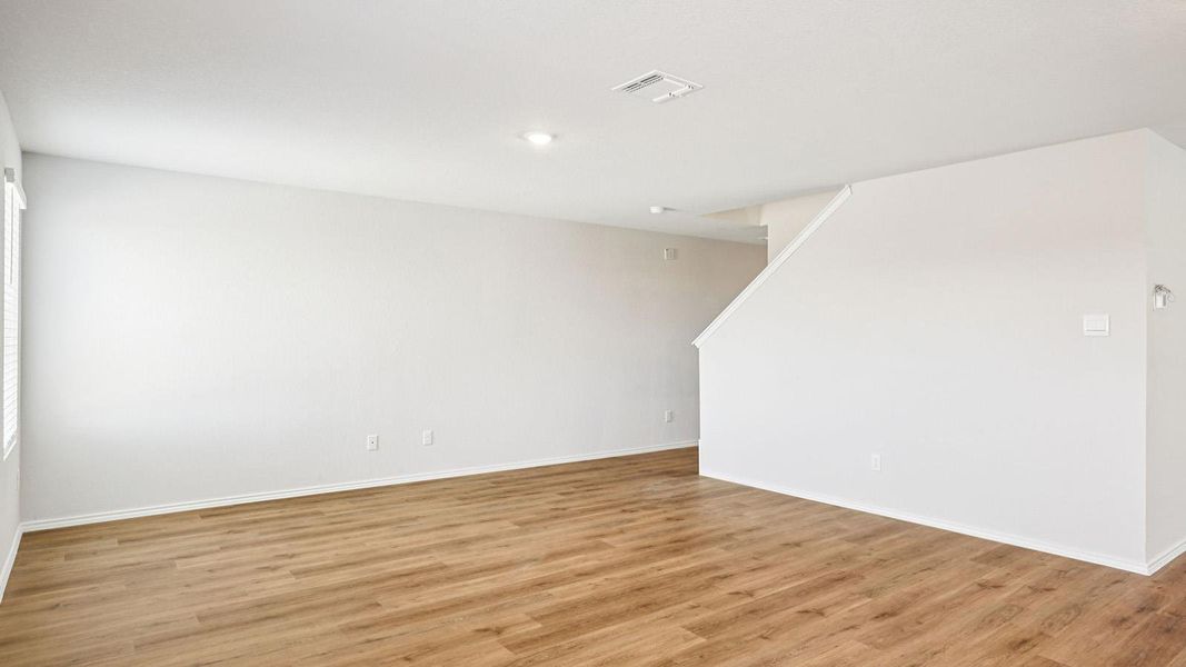 Open-concept living area featuring wood-finish flooring, recessed lighting, white walls, and white trim