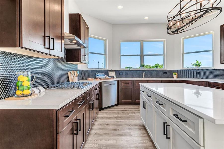 Kitchen with tasteful backsplash, stainless steel appliances, white island cabinets, light hardwood / wood-style floors, and wall chimney exhaust hood