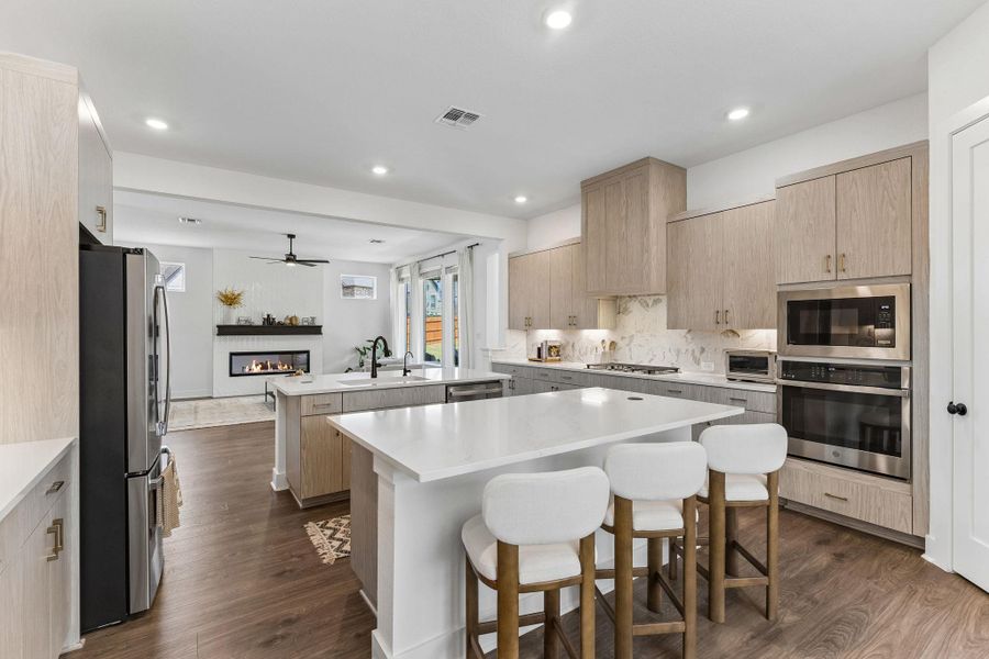 Streamlined cabinetry and pristine stone countertops define this airy open-concept kitchen.