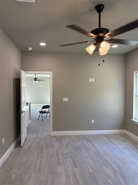 Empty room with ceiling fan, light wood-style flooring, and recessed lighting Empty room with ceiling fan, light wood-style flooring, and recessed lighting