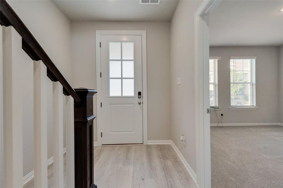 Foyer with light colored carpet