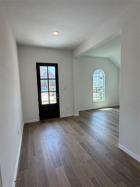 Wide plank wood-finish flooring extends throughout, complemented by white walls and trim