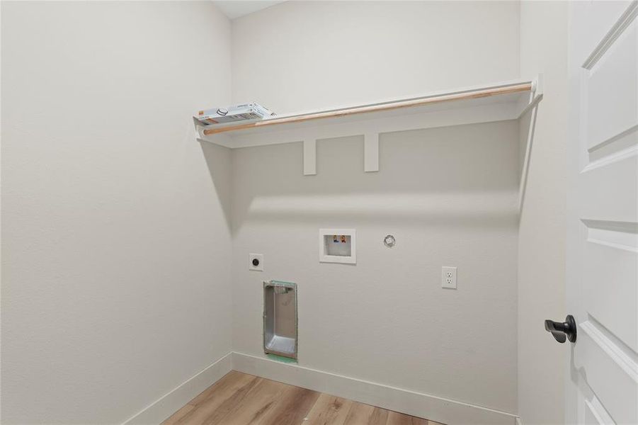 Laundry area featuring light wood-style floors, gas dryer hookup, hookup for an electric dryer, and washer hookup