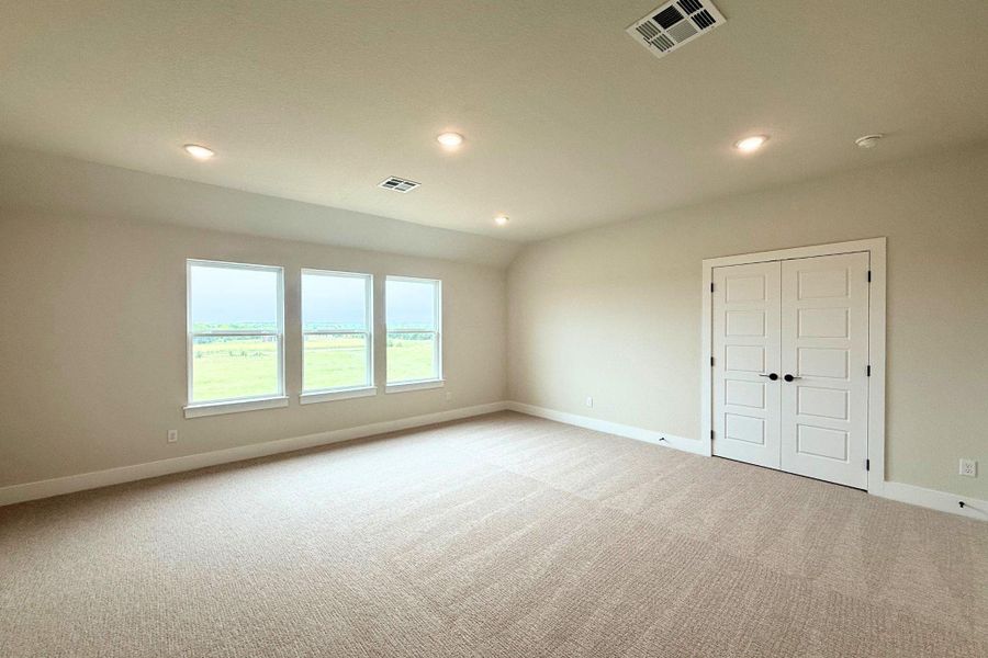 A spacious room offers ample natural light and plush carpeting, ideal for a flexible living space. A spacious room offers ample natural light and plush carpeting, ideal for a flexible living space.