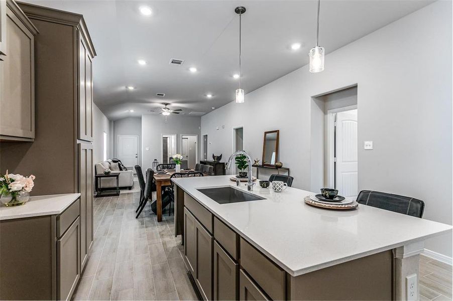 A chef's dream kitchen featuring a large island, sleek countertops, custom cabinetry, and modern pendant lighting. Designed for both functionality and style, it provides ample space for cooking, dining, and entertaining. Whether hosting a dinner party or enjoying a quiet meal, this kitchen caters to every need. **This image is from another Saratoga Home - Mockingbird floorplan.**