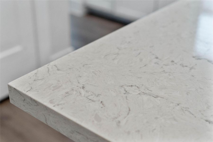 Premium quartz countertops on the island provide a durable, non-porous surface that is as functional for meal prep as it is beautiful. Premium quartz countertops on the island provide a durable, non-porous surface that is as functional for meal prep as it is beautiful.