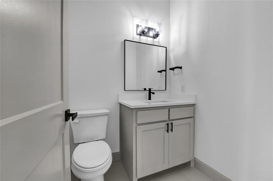 Bathroom with tile patterned flooring, vanity, and toilet