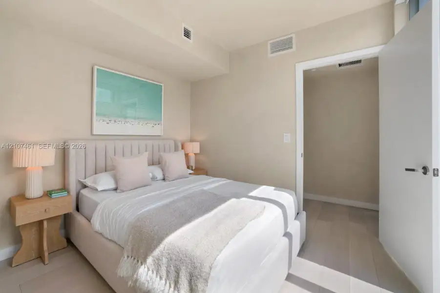 Neutral-toned wall finishes featuring light-finish wood-finish flooring and a minimalist door with brushed metal hardware Neutral-toned wall finishes featuring light-finish wood-finish flooring and a minimalist door with brushed metal hardware