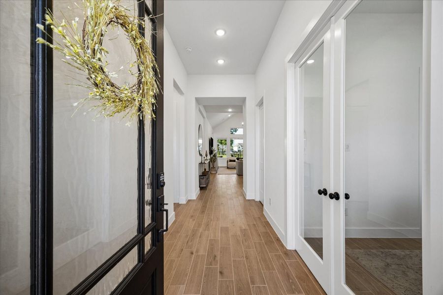 Wide entry hallway draws you in with wood plank look tile flooring and a clean, modern palette, leading sightlines straight through to the main living area. Double glass doors at the front office space add light and definition while maintaining an open feel. Wide entry hallway draws you in with wood plank look tile flooring and a clean, modern palette, leading sightlines straight through to the main living area. Double glass doors at the front office space add light and definition while maintaining an open feel.