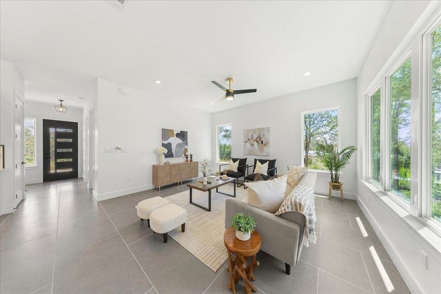 Tiled living area with healthy amount of natural light, ceiling fan, and recessed lighting Tiled living area with healthy amount of natural light, ceiling fan, and recessed lighting