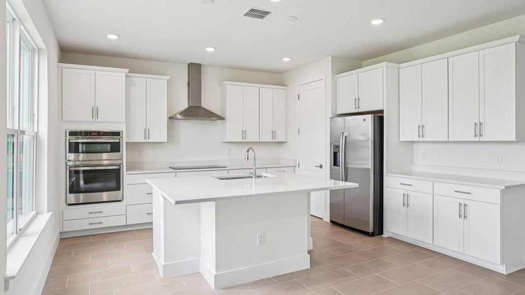 Gourmet kitchen featuring quartz island and stainless appliances at Lakeside at Satilla by DRB Homes. Gourmet kitchen featuring quartz island and stainless appliances at Lakeside at Satilla by DRB Homes.