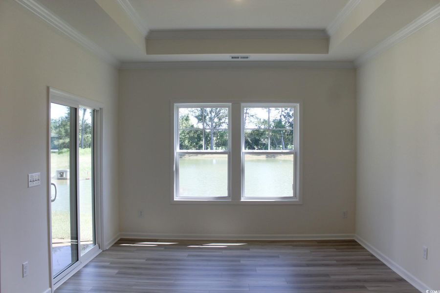 Spare room with a tray ceiling, wood finished floors, and ornamental molding Spare room with a tray ceiling, wood finished floors, and ornamental molding