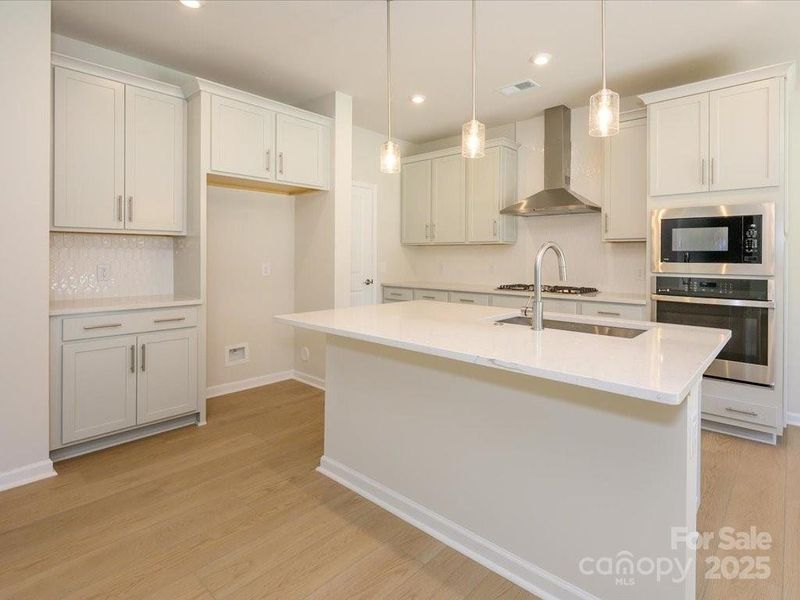 Modern pendant lighting brightens the kitchen and makes the white countertops shine. Modern pendant lighting brightens the kitchen and makes the white countertops shine.