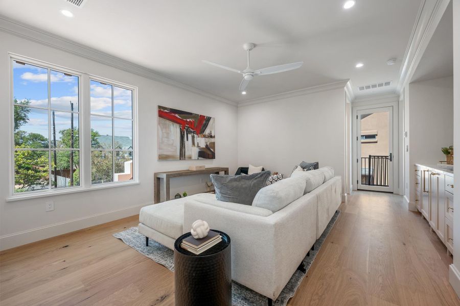 Hardwood floors and crisp crown molding frame this inviting living space complete with built-in cabinetry.