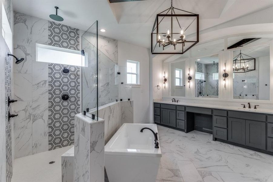 Primary  bathroom with a notable chandelier, shower with separate bathtub, tile walls, and vanity