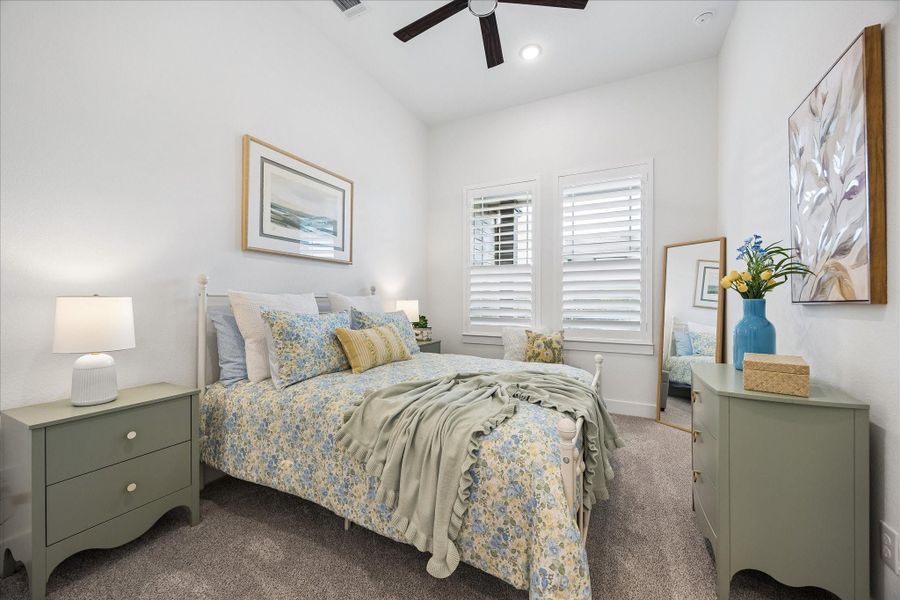 One of the three secondary bedrooms featuring custom plantation shutter, upgraded carpet and ceiling fan.