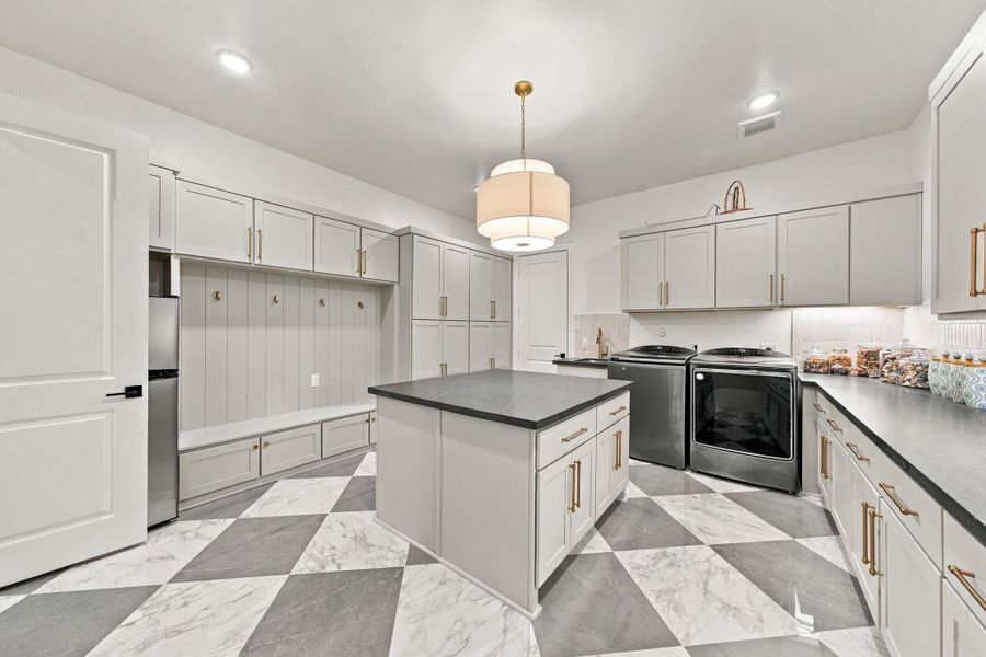 Complete with a dedicated mudroom zone, ample cabinet storage, and space for a full-size washer and dryer, this utility room was designed to keep everyday life organized.