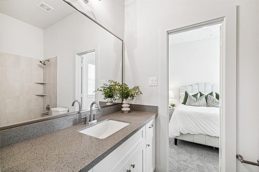 Secondary bathroom connecting both secondary bedrooms features a shower/tub combo and quartz countertop with undermount sink as well as framed mirror.