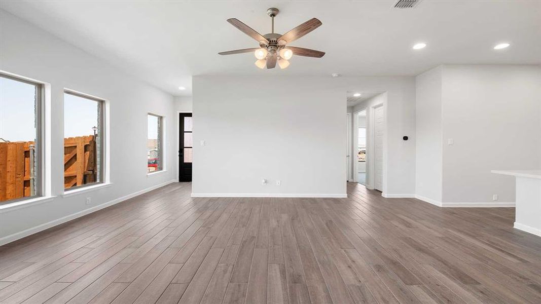 Unfurnished living room featuring wood-type flooring and ceiling fan