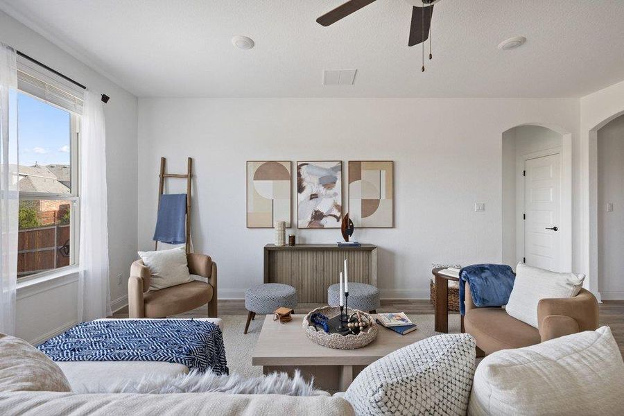 Living area featuring arched walkways, wood finished floors, and ceiling fan Living area featuring arched walkways, wood finished floors, and ceiling fan