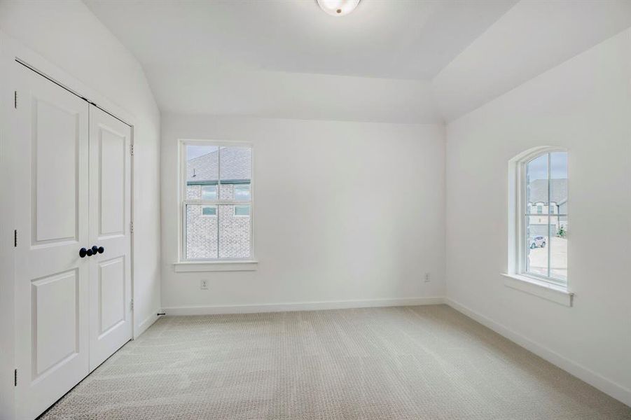 Carpeted room with a tray ceiling and white walls