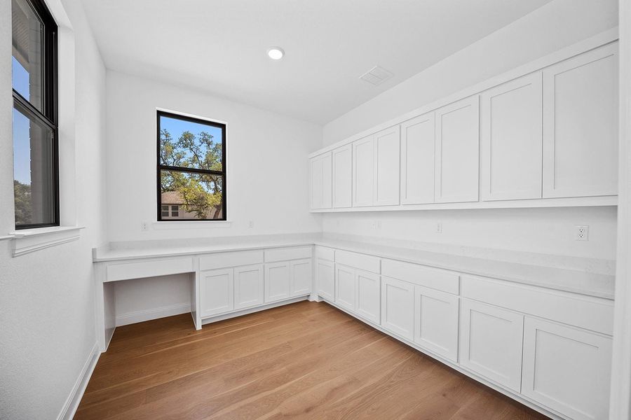 Unfurnished office featuring built in study area, light wood-style floors, and recessed lighting Unfurnished office featuring built in study area, light wood-style floors, and recessed lighting