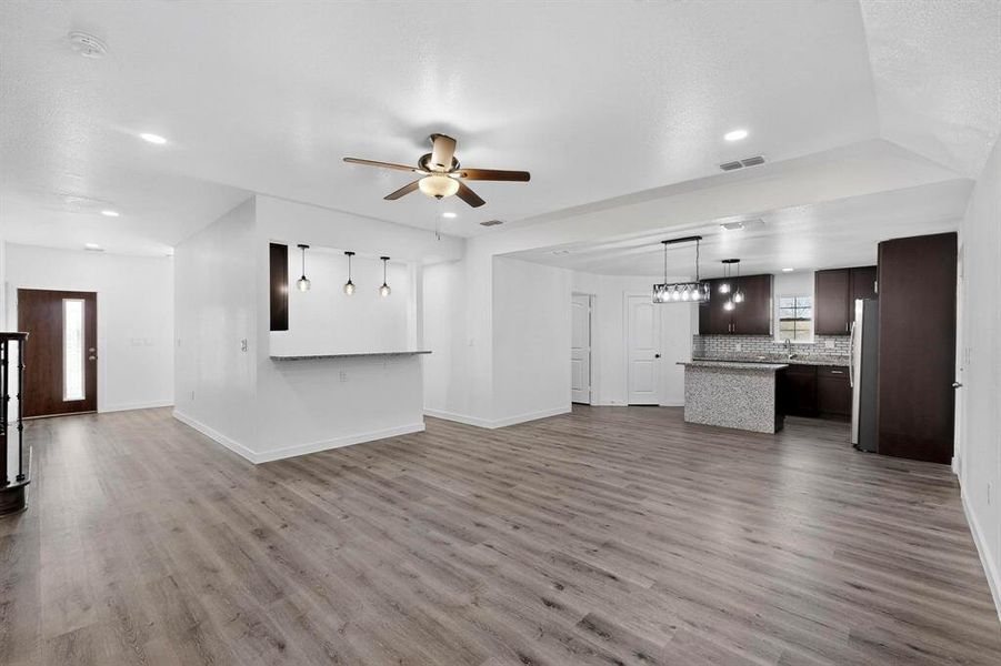 Unfurnished living room featuring dark wood finished floors, a ceiling fan, and recessed lighting