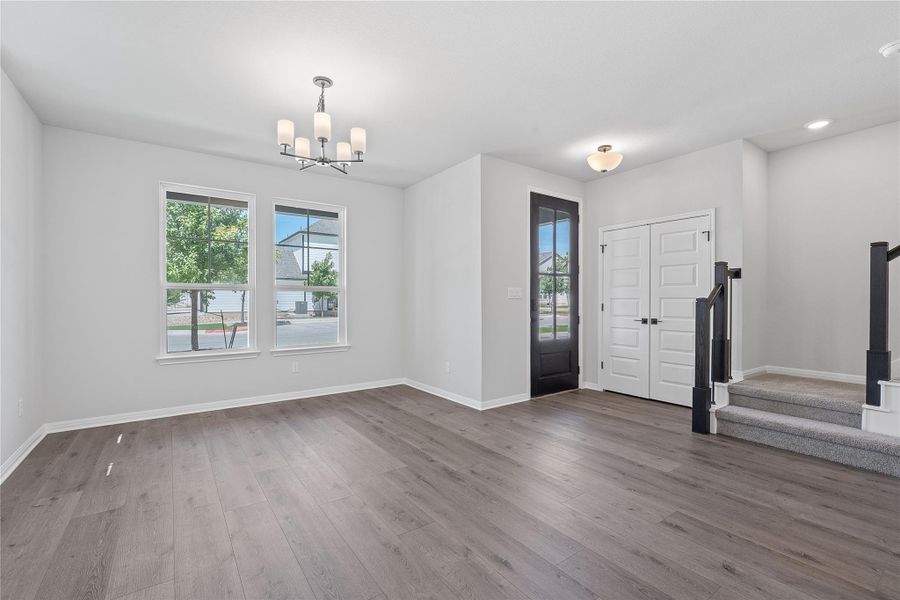 Entrance foyer featuring a chandelier, dark wood-style flooring, and stairs