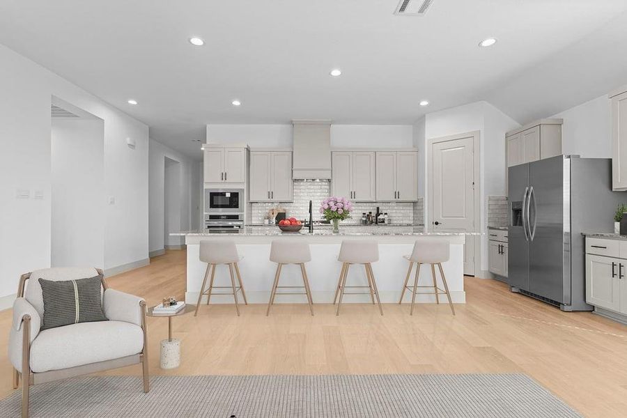 Bright and spacious kitchen with granite countertops, stainless steel appliances, and an island with bar seating. Bright and spacious kitchen with granite countertops, stainless steel appliances, and an island with bar seating.