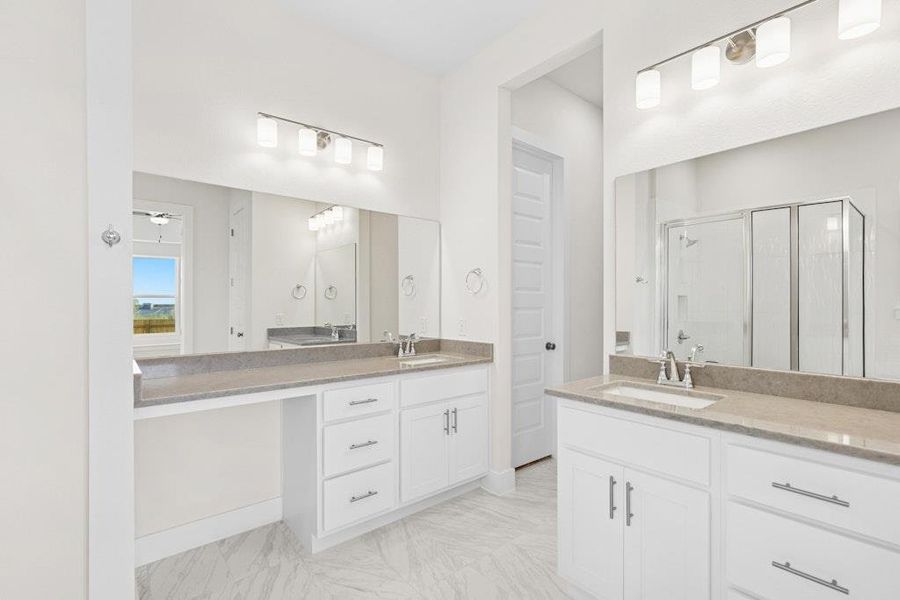 Bathroom with a stall shower, two vanities, and light marble finish floors Bathroom with a stall shower, two vanities, and light marble finish floors