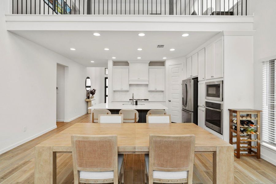Open-concept floor plan featuring elegant wood-look tile, recessed lighting, and a neutral palette that flows perfectly from the dining area to the chef’s kitchen. Open-concept floor plan featuring elegant wood-look tile, recessed lighting, and a neutral palette that flows perfectly from the dining area to the chef’s kitchen.