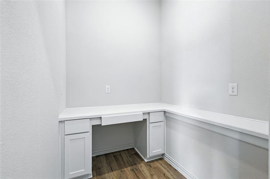 Unfurnished office with built in desk and dark wood-style floors Unfurnished office with built in desk and dark wood-style floors