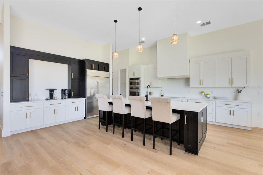 Your gorgeous chef-inspired kitchen boasts a quartz-topped breakfast bar, sleek quartz counters, and a convenient sideboard area that’s perfect for a coffee and drink station.