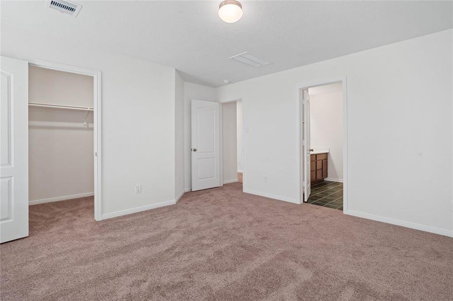 Another view of this primary suite looking into the primary bathroom and walk-in closet.