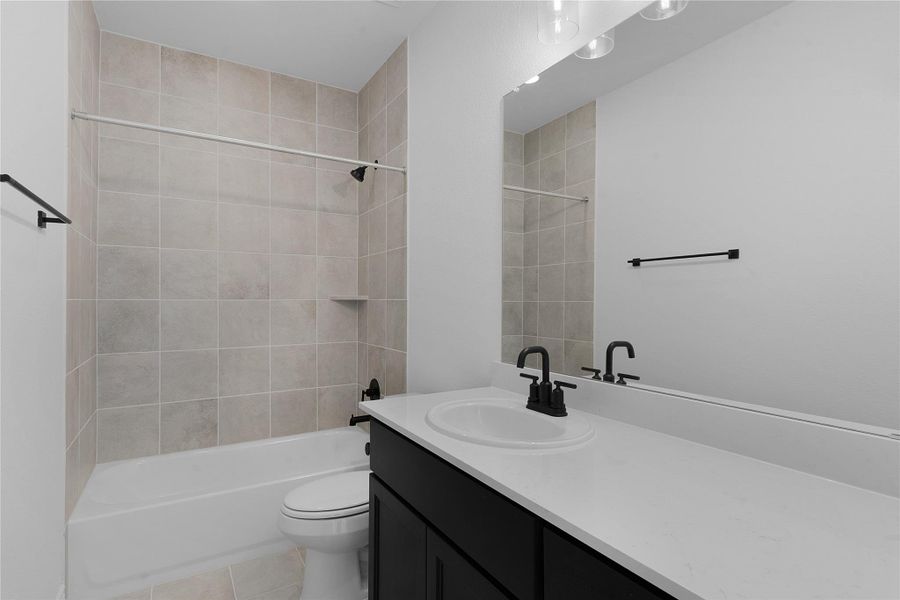 Bathroom with vanity, tub / shower combination, and light tile patterned flooring