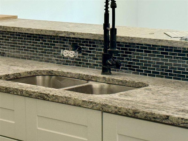 Kitchen view of white cabinets and light stone countertops
