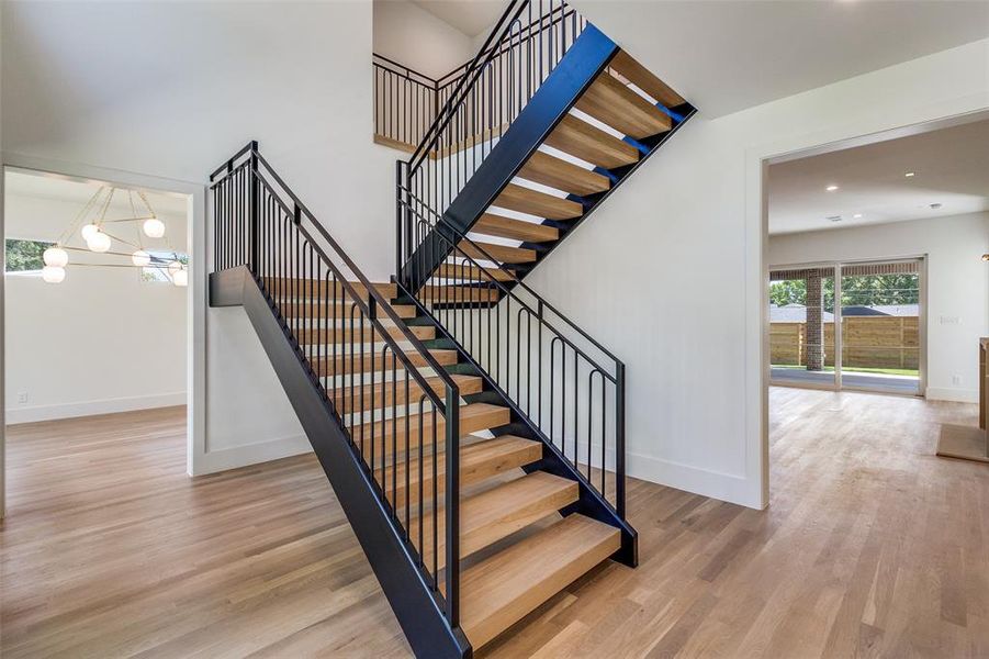 Stairs with healthy amount of natural light, wood finished floors, and recessed lighting Stairs with healthy amount of natural light, wood finished floors, and recessed lighting