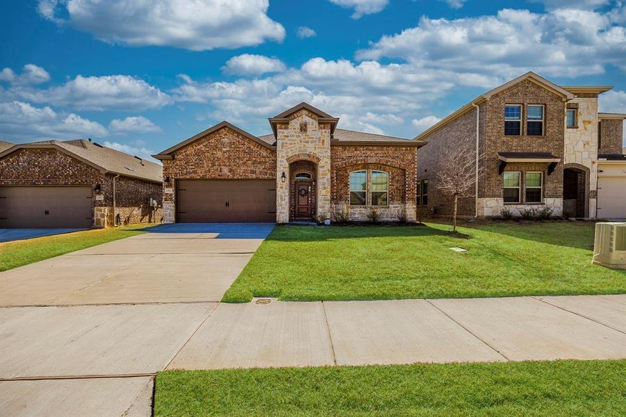 View of front of property with a front lawn and a garage