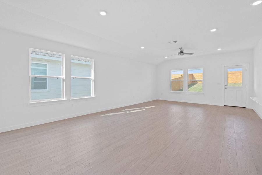 Empty room with recessed lighting, light wood-type flooring, a ceiling fan, and vaulted ceiling