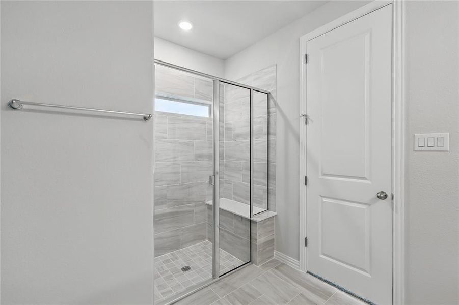Bathroom with a shower stall and baseboards