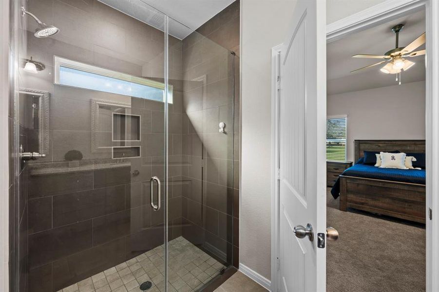 Super sized frameless shower with tile surround. Windows allow natural light to stream in. No backyard neighbor allows the ultimate privacy in this tranquil oasis.