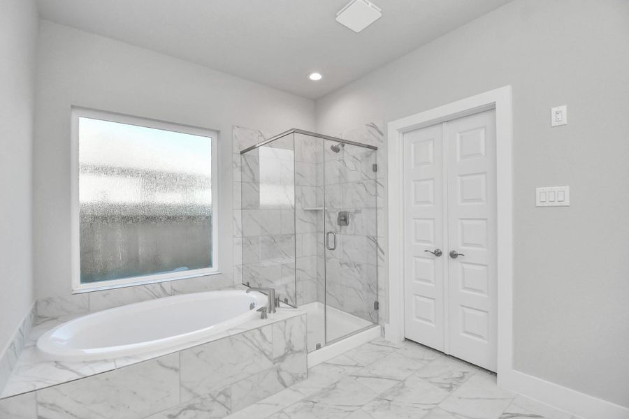 Indulge in a spa-like retreat within the confines of this primary bathroom. Delight in a spacious walk-in shower enveloped in stylish tile surround and unwind in a separate garden tub adorned with custom detailing.